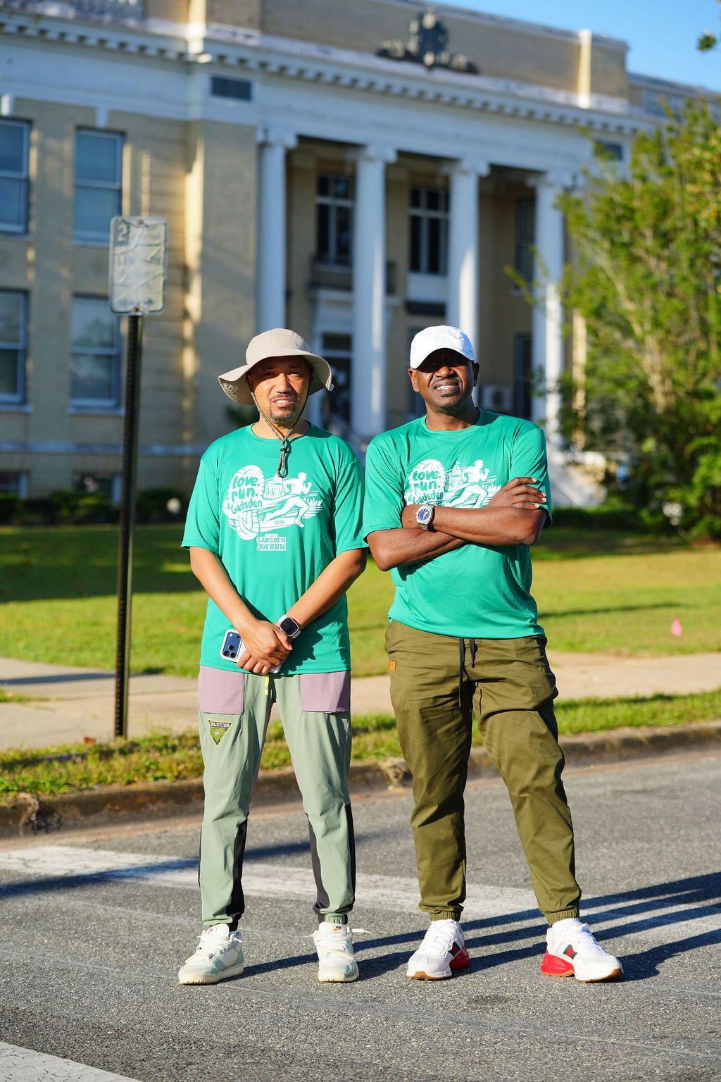 The founders of the Gadsden 5K Run standing in front of the historic Gadsden County courthouse in their 2026 race shirts