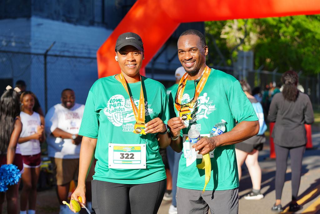 Two finishers showing off their medals in 2026