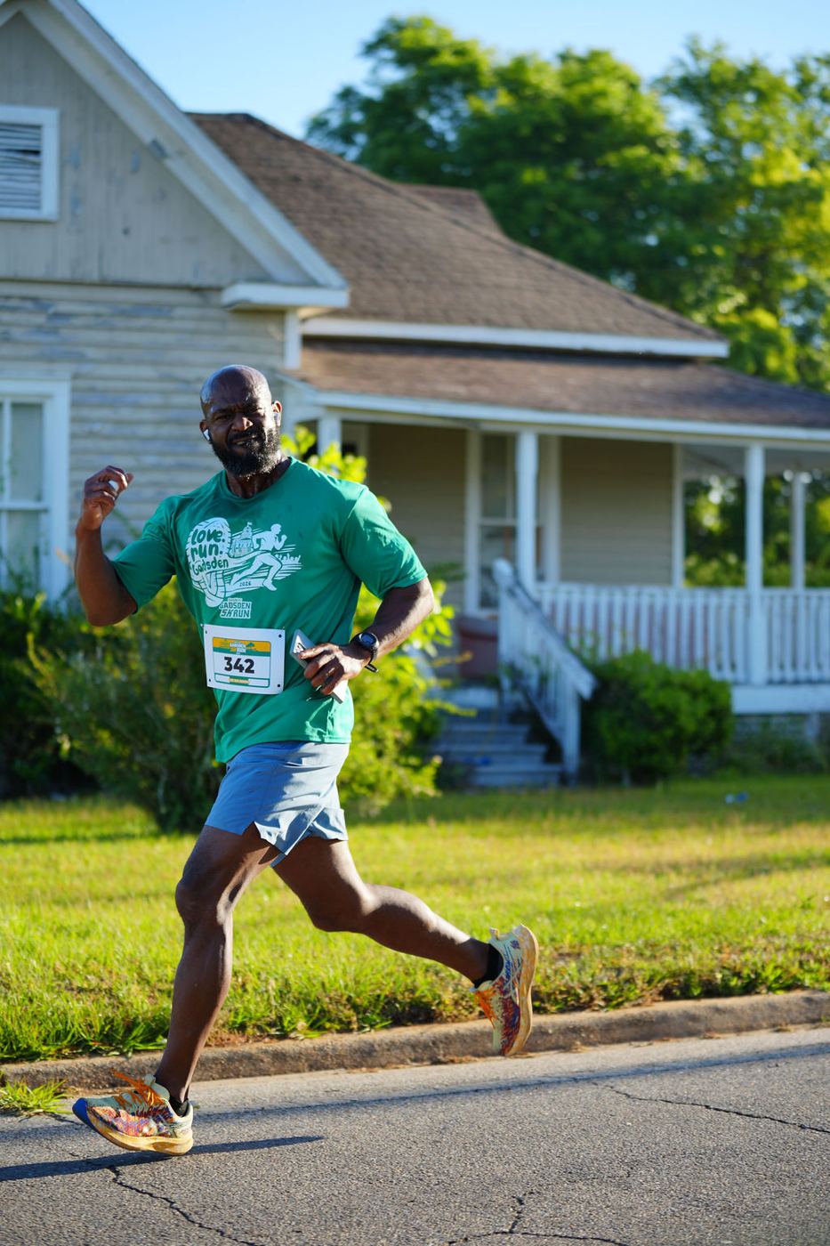 A runner mid-stride passing a historic Quincy home in 2026